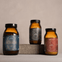 Three brown glass jars with labels on a neutral background. Wild Collagen, True Creatine and True Nightcap.