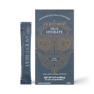 A box and sachet of Ancient + Brave True Hydrate Sachets, an advanced electrolyte mineral blend for active lifestyles, featuring gold geometric designs on a dark background. Vegan and dietary supplement details included.
