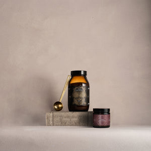 Two bottles with labels on a gray surface and background. True Collagen and Noble Collagen.