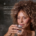 Woman holding a glass of water with text about adding a True Creatine to water or beverages.
