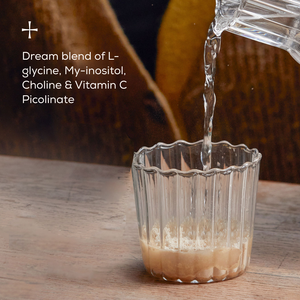 A glass with powder from Ancient + Braves True Nightcap Sachets sits on a wooden table as water is poured in. Text highlights its soothing blend of targeted nutrients: L-glycine, My-inositol, Choline, and Vitamin C Picolinate.