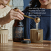 Two people prepare drinks; one scoops Ancient + Brave Wild Collagen into a mug. Text highlights whole-body health benefits, neutral taste, easy dissolving, and suitability for hot or cold drinks.