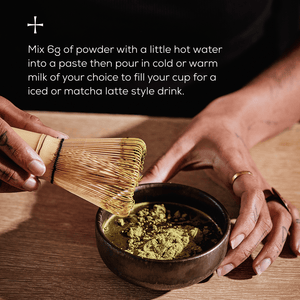A person uses a bamboo whisk to mix Ancient + Brave Matcha + Collagen powder in a bowl on a wooden table, with matcha latte instructions shown at the top left of the image.