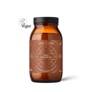 A brown glass jar labeled Ancient + Brave True Nightcap features gold text, a geometric design, and a Vegan logo. It contains a soothing lemon and blackcurrant flavored advanced nutrient nightcap powder.