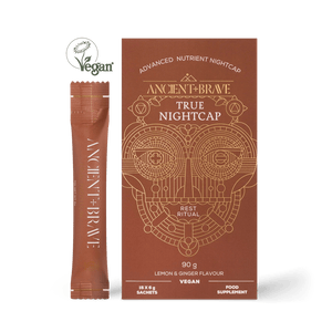 A box of Ancient + Brave True Nightcap Sachets, a vegan lemon & ginger-flavored night-time food supplement with targeted nutrients to support restful sleep. Presented in brown packaging with a gold geometric design.